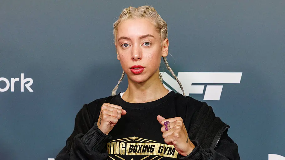 Walentina Doronina will ins Dschungelcamp Walentina Doronina posiert mit erhobenen Fäusten, geflochtenen Haaren und schwarzem „Boxing Gym“-Shirt vor einer Logowand.