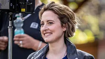 Schauspielerin Wanda Perdelwitz lächelt am Filmset, während neben ihr eine Kamera aufgebaut ist. - Foto: RTL / Redseven Entertainment / Behrus Yazdanfar