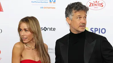 Annemarie im roten Kleid und Wayne Carpendale im schwarzen Anzug stehen sich gegenüber und drehen sich voneinander weg. - Foto: IMAGO / Bildagentur Monn Annemarie im roten Kleid und Wayne Carpendale im schwarzen Anzug stehen sich gegenüber und drehen sich voneinander weg. - Foto: IMAGO / Bildagentur Monn