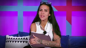Elena Miras sitzt mit Armschlinge auf einem Sofa in einer Reality-TV-Kulisse, trägt ein weißes Oberteil, blickt ernst in die Kamera und hält ihren verletzten Arm schützend, im Hintergrund sind farbige Wandpaneele zu sehen. - Foto: RTL