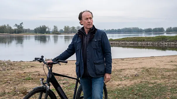 Jakob Stiller (Ulrich Noethen) steht mit seinem Fahrrad am Ufer. - Foto: ZDF/Manju Sawhney Jakob Stiller (Ulrich Noethen) steht mit seinem Fahrrad am Ufer. - Foto: ZDF/Manju Sawhney
