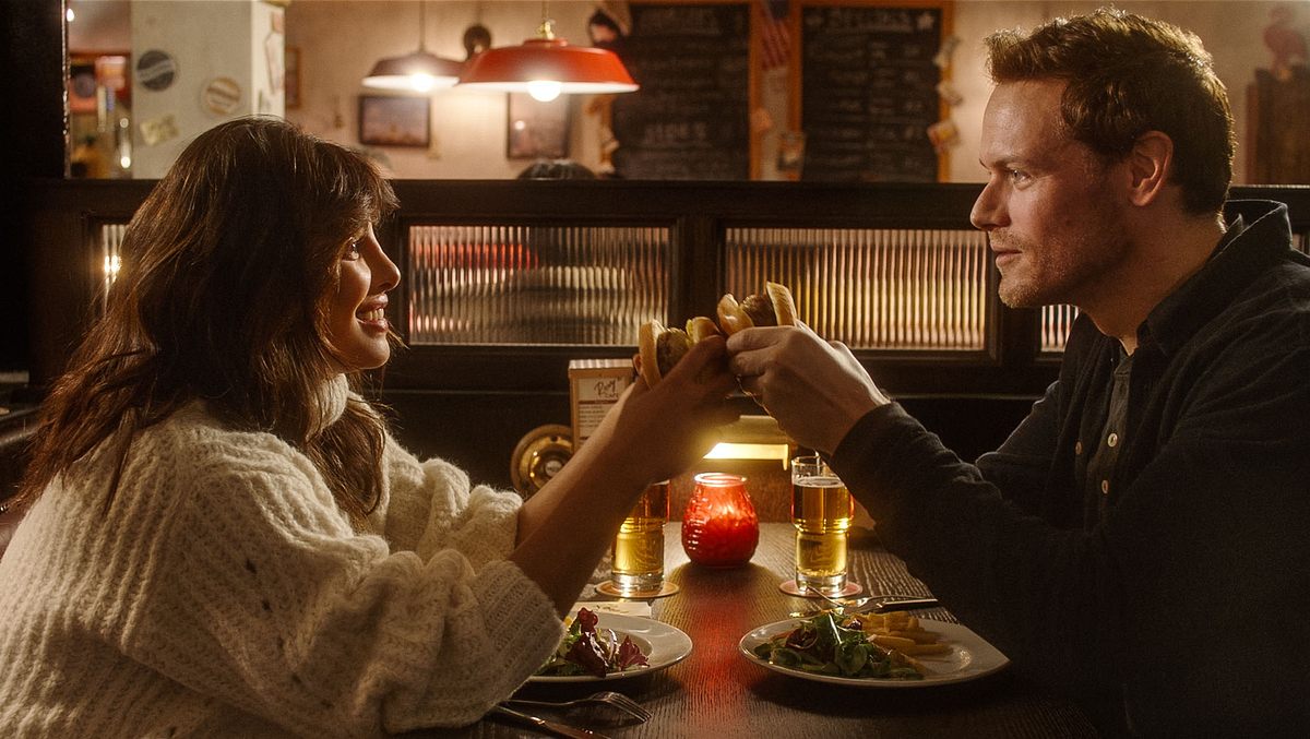 „Love Again“: Mira und Rob sitzen gegenüber an einem Tisch und halten Händchen