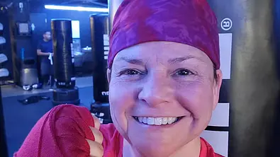 Wenne Alton David mit rotem Tuch auf dem Kopf, hält ihre Faust in die Kamera und lächelt - Foto: Instagram/wenne_alton_davis