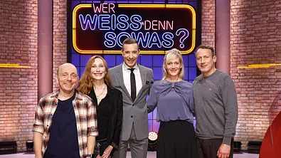 Kai Pflaume steht mit Andrea Sawatzki, Anna Schudt sowie den Teamkapitänen Bernhard Hoecker und Wotan Wilke-Möhring im Studio von „Wer weiß denn sowas?“ vor dem leuchtenden Show-Logo. - Foto: ARD/NDR/UFA SHOW & FACTUAL/Morris Mac Matzen