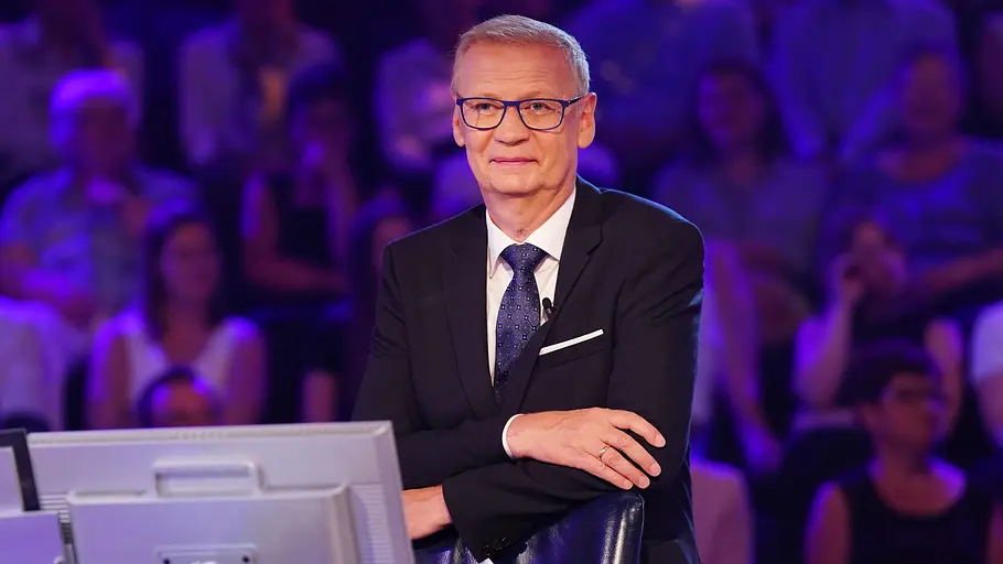Wer wird Millionär? Günther Jauch lehnt lässig an seinem Moderationsstuhl.