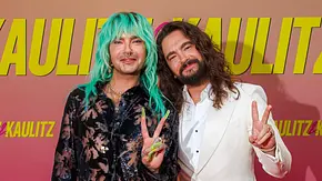 Bill und Tom Kaulitz bei der Premiere von Kaulitz und Kaulitz von Netflix, lächeln in die Kamera und machen mit der Hand ein Peace-Zeichen. - Foto: IMAGO / Eventpress