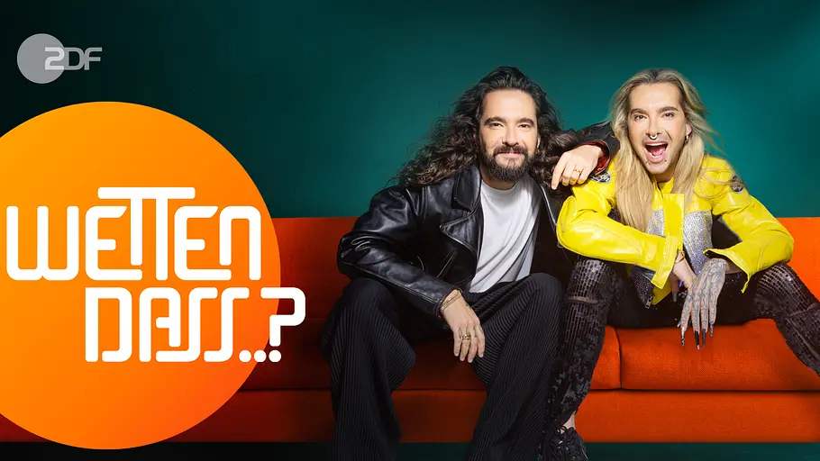 Neues „Wetten, dass..?“-Logo für die Kaulitze Tom und Bill Kaulitz sitzen in schwarzer und gelber Jacke auf einem orangefarbenen Sofa neben dem „Wetten, dass..?“-Logo.
