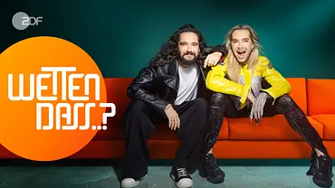 Tom und Bill Kaulitz sitzen nebeneinander auf einer roten Couch. Tom legt seine Arm auf die Schulter von Bill. Beide schauen in die Kamera. Im linken Bildrand steht das Logo von Wetten, dass in einem orangefarbenen Kreis. - Foto: ZDF und Rankin