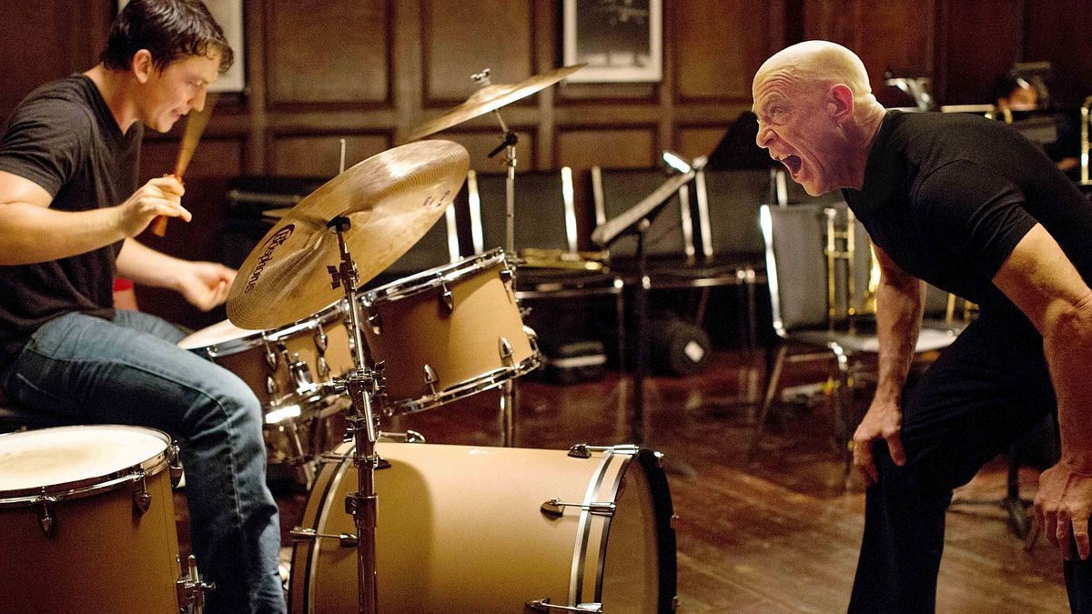 Whiplash Miles Teller spielt links Schlagzeug, während J.K. Simmons ihn von rechts anschreit.