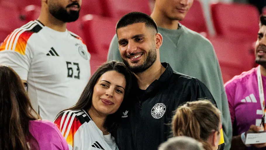 Spielerfrauen unserer DFB-Stars Tanja kuschelt sich an ihren Ehemann Deniz an, während die beiden mit Freunden reden.