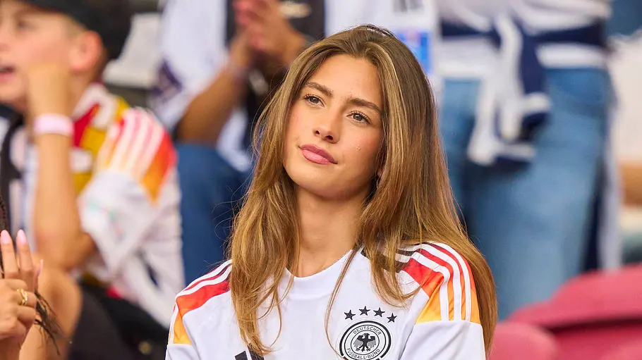 Spielerfrauen unserer DFB-Stars Sophia sitzt im Deutschlandtrikot auf der Tribüne und schaut das Spiel an.
