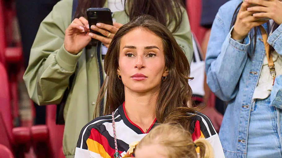Spielerfrauen unserer DFB-Stars Jenni sitzt mit ihrer Tochter auf der Tribüne und schaut aufs Spiel.