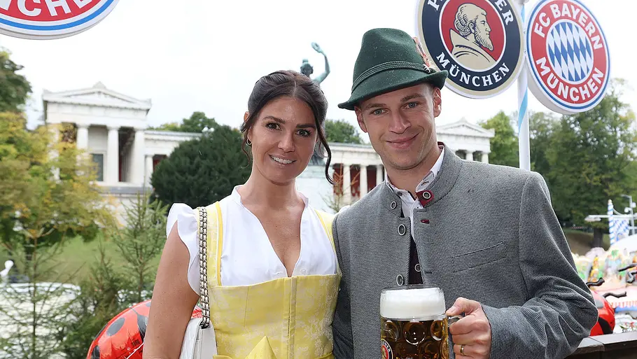 Spielerfrauen unserer DFB-Stars Joshua und Lina Kimmich in Tracht auf dem Oktoberfest. Beide lächeln, und er hält ein Bier.