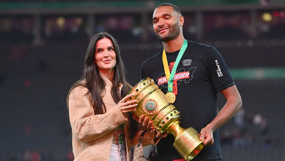 Spielerfrauen unserer DFB-Stars Luisa und Jonathan Tah halten den DFB-Pokale und lächeln.