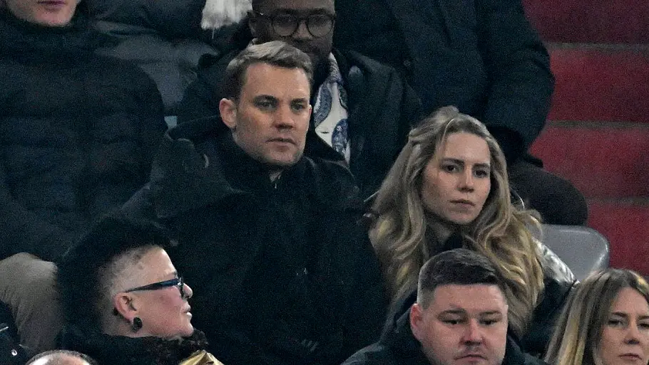 Spielerfrauen unserer DFB-Stars Manuel Neuer und seine Frau Anika bei einem Fußballspiel. Beide schauen gebannt auf das Spielfeld.