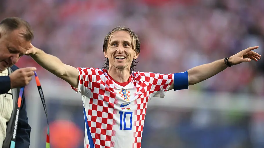  Luka Modric hebt die Arme und läuft lächelnd übers Feld.