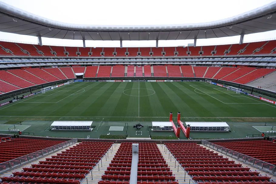 Akron Stadium Panoramaansicht eines großen, modernen Fußballstadions mit roten Sitzreihen und teilweise überdachtem Rang. Das Spielfeld ist frisch gemäht und leer, in der Mitte verläuft der Anstoßkreis; am Spielfeldrand stehen Mannschaftsbänke und Zugänge zum Platz.
