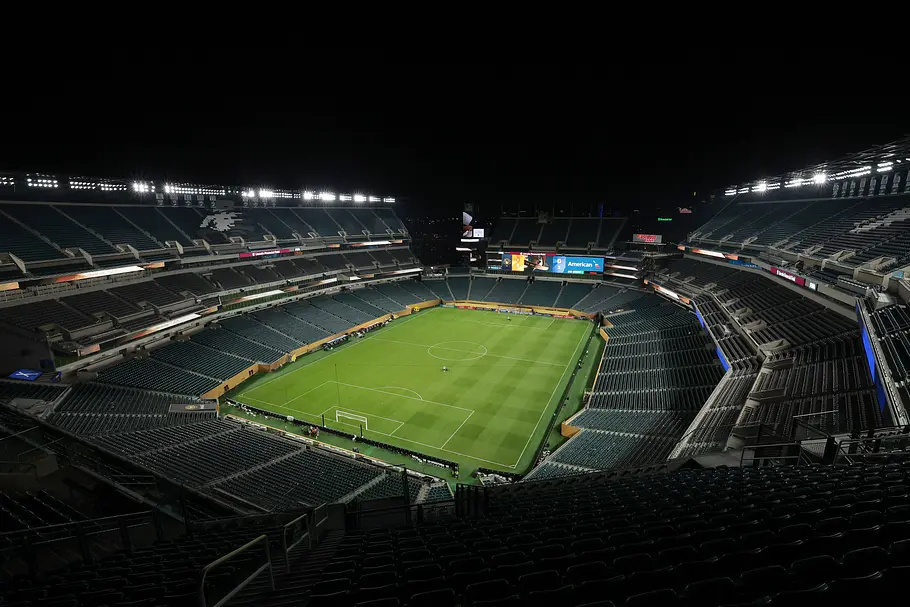 Lincoln Financial Field Philadelphia Weitläufiges, nahezu leeres Fußballstadion bei Nacht mit hell ausgeleuchtetem Rasen, grünen Sitzreihen auf mehreren Rängen, großer Videotafel an der Stirnseite und dunklem Himmel über der teilweise überdachten Tribüne.