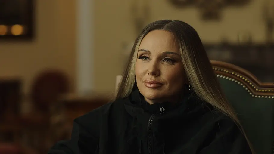 Schwesta Ewa Interviewaufnahme von Schwesta Ewa mit langen blonden Haaren in einem stilvoll eingerichteten Raum.