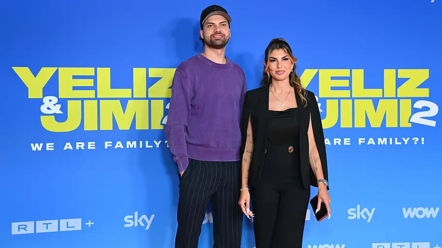 Yeliz und Jimi kommt Staffel 3? Jimi Blue Ochsenknechtund Yeliz Koc auf dem roten Teppich zum Auftakt der 2. Staffel des Sky Originals Yeliz & Jimi - We are Family?. Bei stehen vor einem blauen Banner.