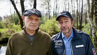 Spreewaldkrimi - Böses muss mit Bösem enden: Krüger (Christian Redl) und Fichte (Thorsten Merten) stehen im Wald und blicken in die Kamera. Fichte trägt seine Polizeiuniform. - Foto:  ZDF/Arnim Thomaß