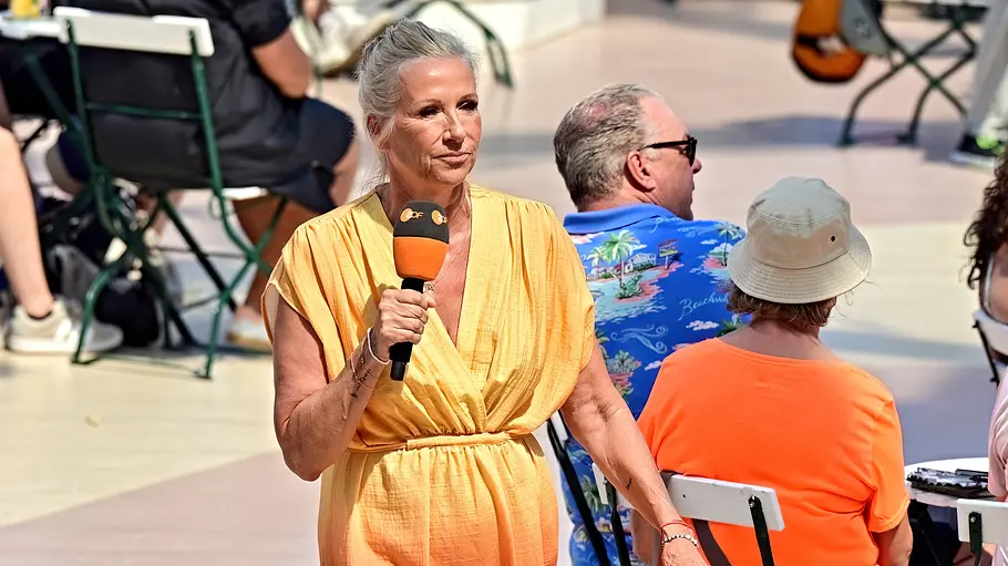 Andrea Kiewel Andrea Kiewel schreitet mit ernster Miene durch den Fernsehgarten.
