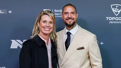 Zico Banach und Pia Tillmann lächeln gemeinsam bei einem Event und posieren vor einer Fotowand - Foto: IMAGO / Oliver Langel