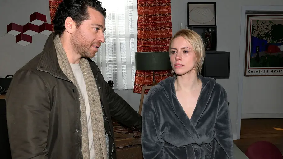 Hintergeht Zoe ihren Mann Carlos? Zoe schaur gedankenverloren, während Carlos zu ihr runterblickt.