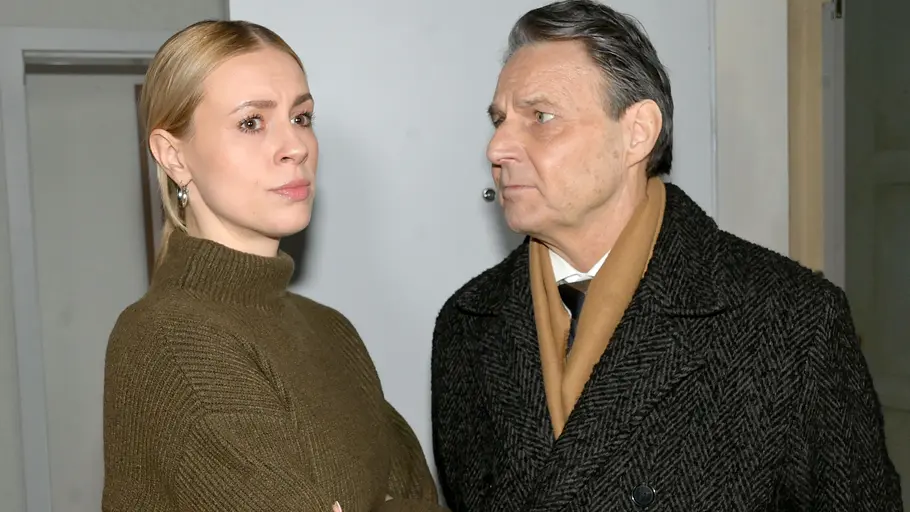 Zoe mit verschränkten Armen, während Gerner sie flehend ansieht.