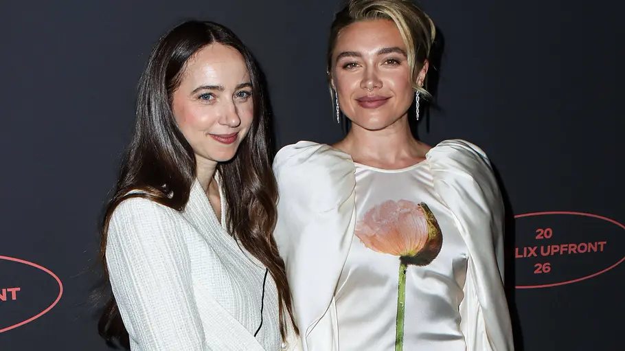 Zoe Kazan hat die Serie mit Hauptdarstellerin Florence Pugh umgesetzt. Zoe Krazan und Florence Pugh posieren vor dunkler Fotowand, eine im weißen Blazer, die andere im weißen Kleid mit Puffärmeln und Blumenmotiv.