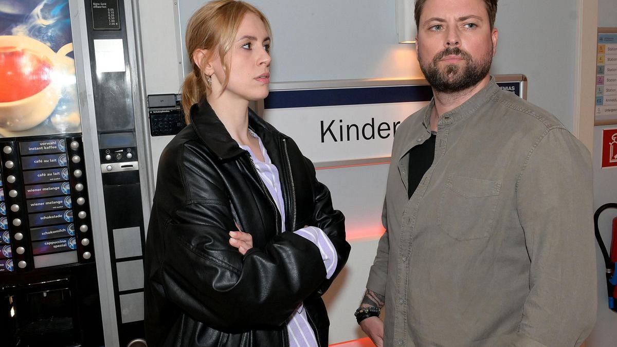 Zoe mit verschränkten Armen vor John.