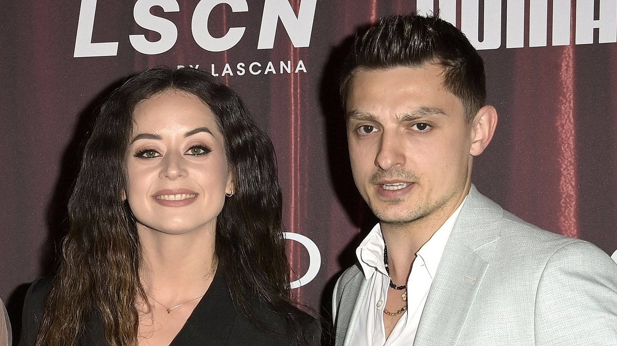 Zsolt spricht über neue Freundin und Malika Zsolt Sándor Cseke mit seiner Tanzpartnerin und Ex-Freundin Malika Dzumaev vor einer Fotowand bei einem Event.